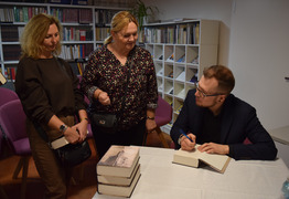 autor dokonuje wpisu do książki (photo)