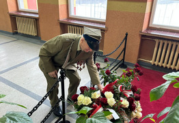 kombatant składa kwiaty pod tablicą pamiątkową w szkole (photo)